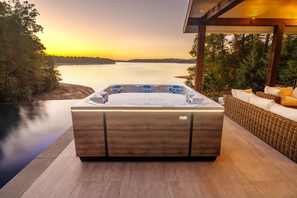 Bullfrog M9 hot tub on a lakeside patio at sunset